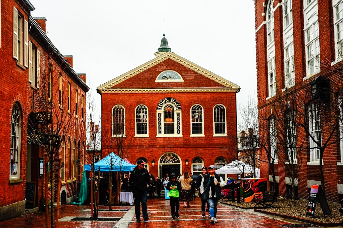 Historic red brick New England town hall with people walking past