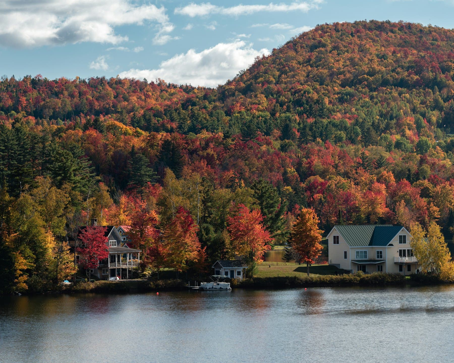 New England homes framed by autumn foliage beside a lake in Massachusetts