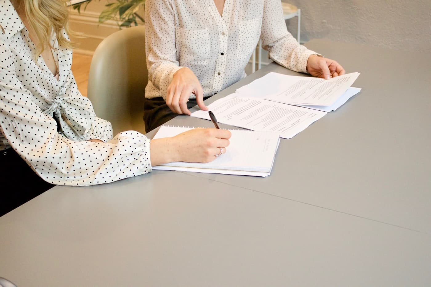 Two people reviewing and signing legal documents at a table